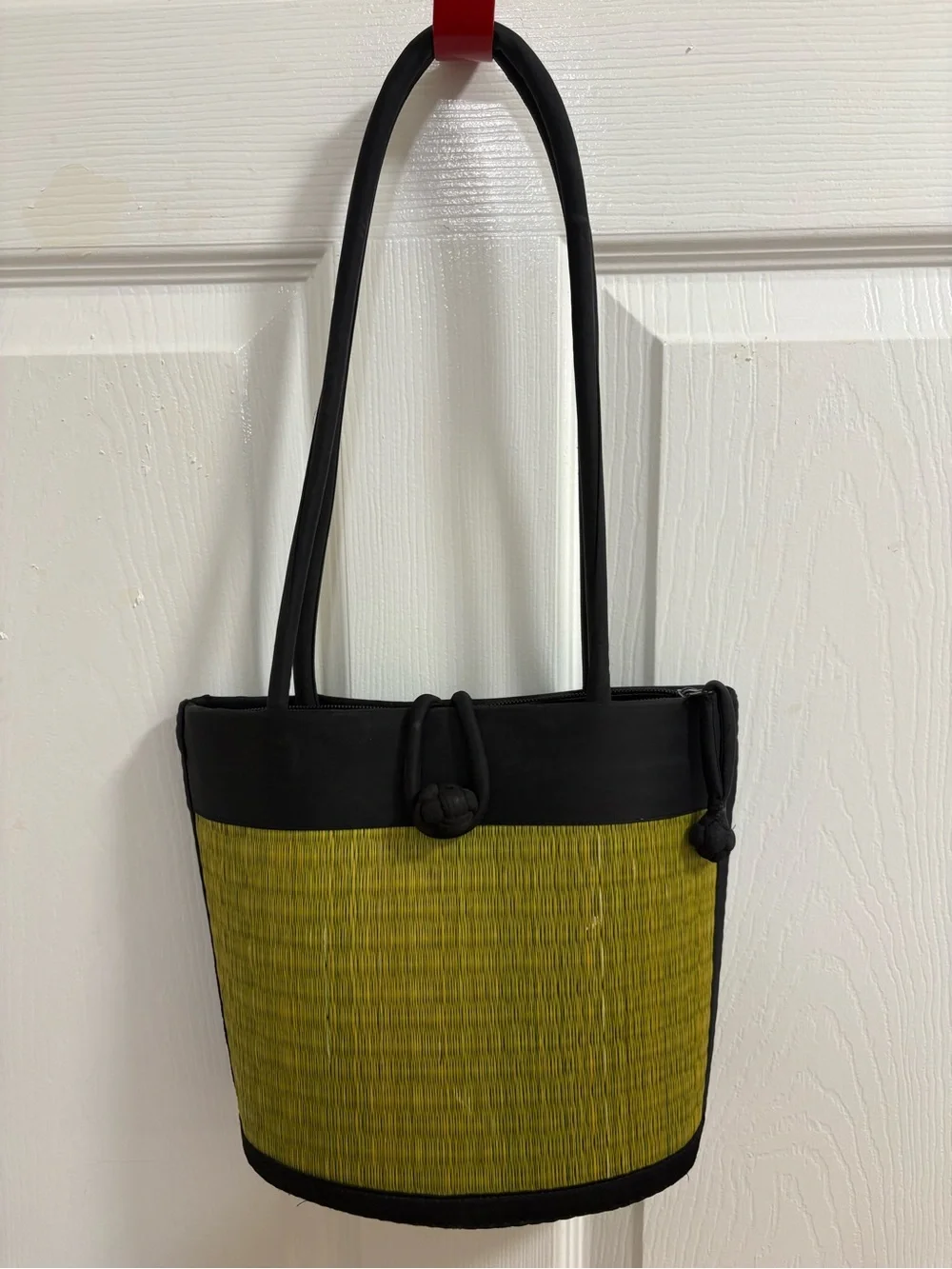 a handwoven green and black tatami grass short shoulder bag. Curved in design
